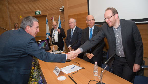 Nadav Kadar shakes hands with prize recipient Prof. Ady Arie. Also pictured are, from right: TAU President Joseph Klafter, Chairman of the Board of Governors Jacob A. Frenkel and Vice President for Research and Development Yoav Henis
